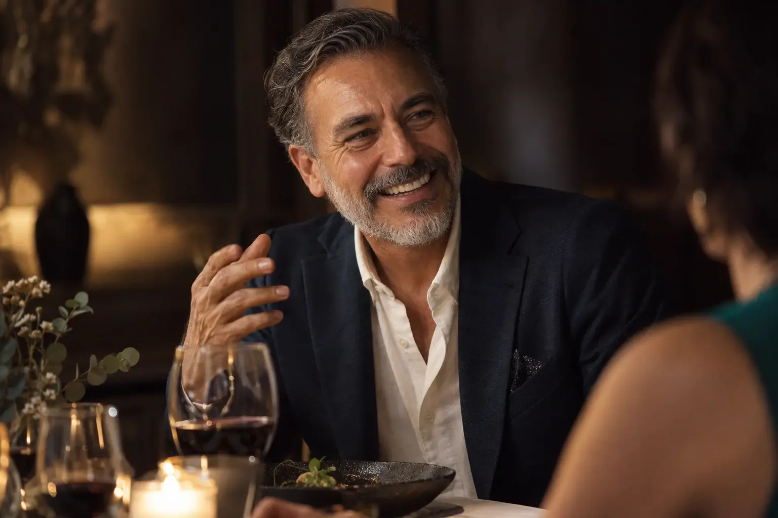Hombre de unos sesenta años sonriendo con naturalidad durante una cena
